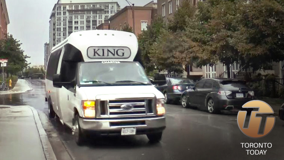 A photo of a white van driving down a street, with 'KING' written in a grey bubble at the front of the car. 'TORONTO TODAY' is written in white text, with 'TT' carved out of an orange circle above.