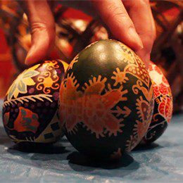 A close up photo of three decorative eggs, which are mainly black in colour with red patterns.